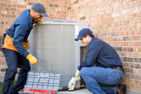 men repairing ac